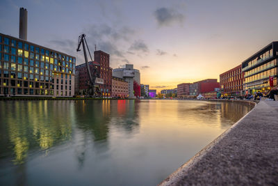 Reflection of buildings in city at sunset