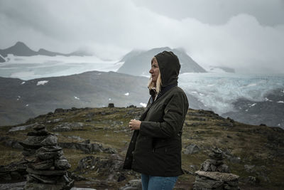 Woman standing in front of snowcapped mountains