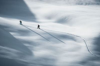 Silhouette of two skiers ski touring in the backcountry of the alps in lienz, austria.