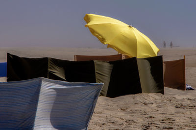 Yellow flag on beach against sky