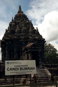 Low angle view of text on building against sky