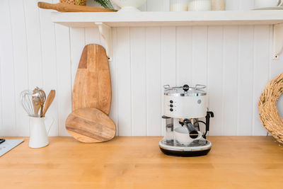 Modern coffee machine with cup on counter in kitchen