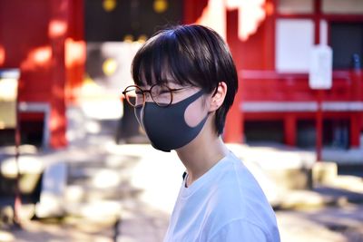 Close-up of woman wearing mask looking away standing outdoors