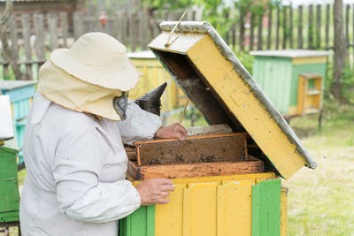 Beekeeper holding tray of honeycomb at park