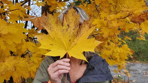 Person holding maple leaves during autumn