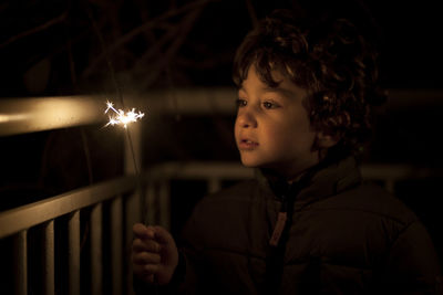 Portrait of boy looking away at night