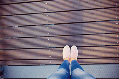 Low section of person standing on wood