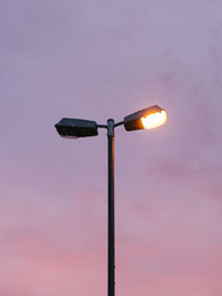 Low angle view of illuminated street light against sky