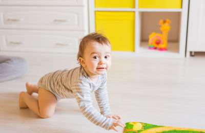 Cute girl sitting on floor at home