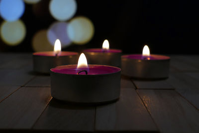 Close-up of illuminated tea light candles on table