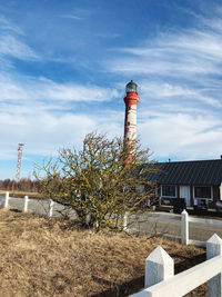 Lighthouse by sea against sky
