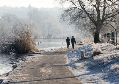 People on snow covered trees during winter