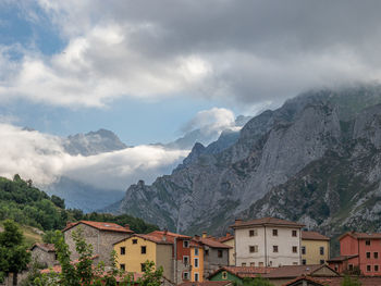 Scenic view of residential buildings and mountains against sky