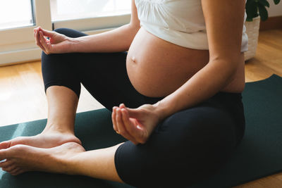 Midsection of woman sitting at home