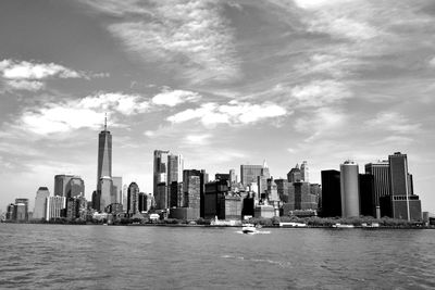 Modern buildings by sea against sky in city