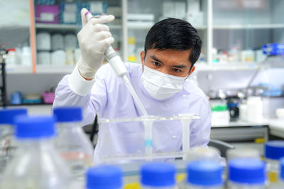 Female scientist holding chemical in laboratory