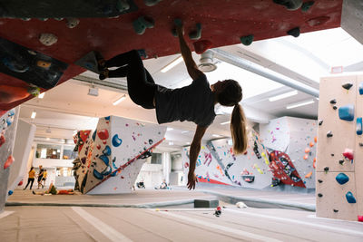 Woman practicing wall climbing in gym