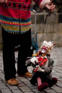 Low section of puppeteer and marionette performing street theatre