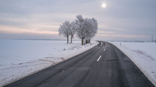 Scenic view of snow covered field against sky during sunset