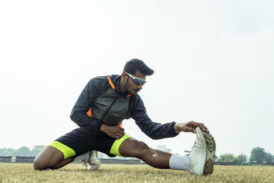 Side view of man exercising against clear sky