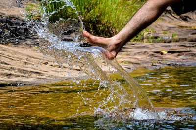 Close-up of person hand on wet river