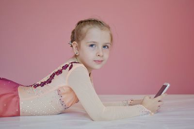 Portrait of cute girl using mobile phone on bed