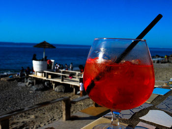 Close-up of beer in sea against clear sky