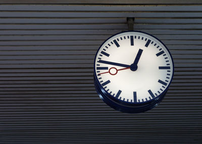 Low angle view of clock hanging on ceiling at railroad station