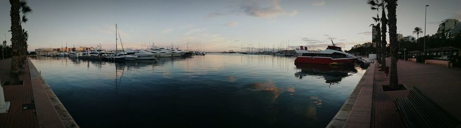 Boats moored in water against sky