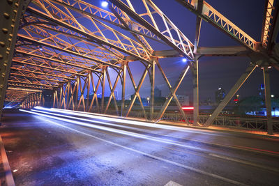 Light trails on bridge in city at night