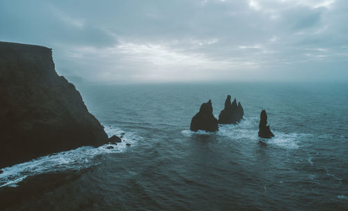 Scenic view of rocks in sea against sky