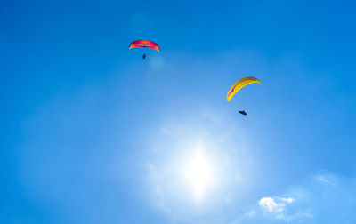 Low angle view of paragliding against sky