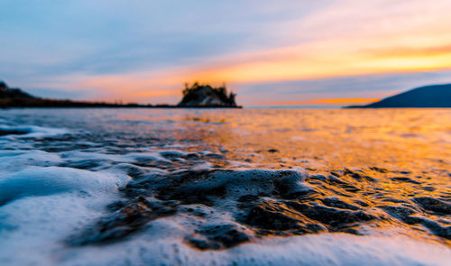 Close-up of sea against sky during sunset