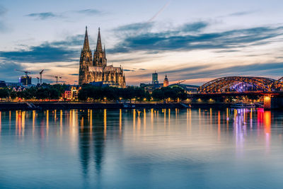 Panoramic view of cologne cathedral with hohenzollern bridge at nightfall, germany.