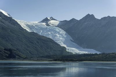 Scenic view of lake and snowcapped mountains against sky