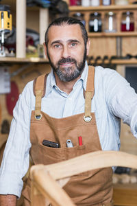 Portrait of carpenter standing in workshop