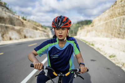 Side view of man riding bicycle on road
