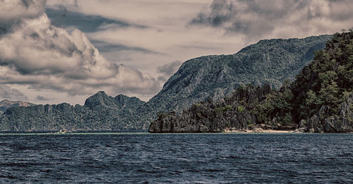 Scenic view of sea and mountains against sky