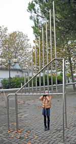 Rear view of people standing by metal structure