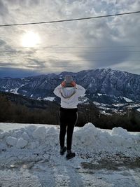 Man standing on snowcapped mountain against sky