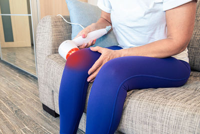 Low section of woman sitting on seat at home