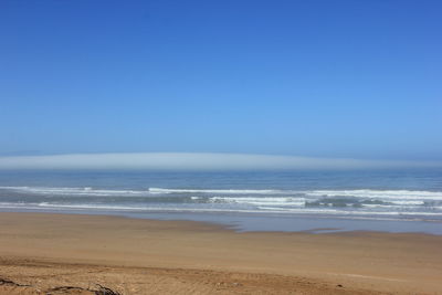 Scenic view of sea against clear blue sky