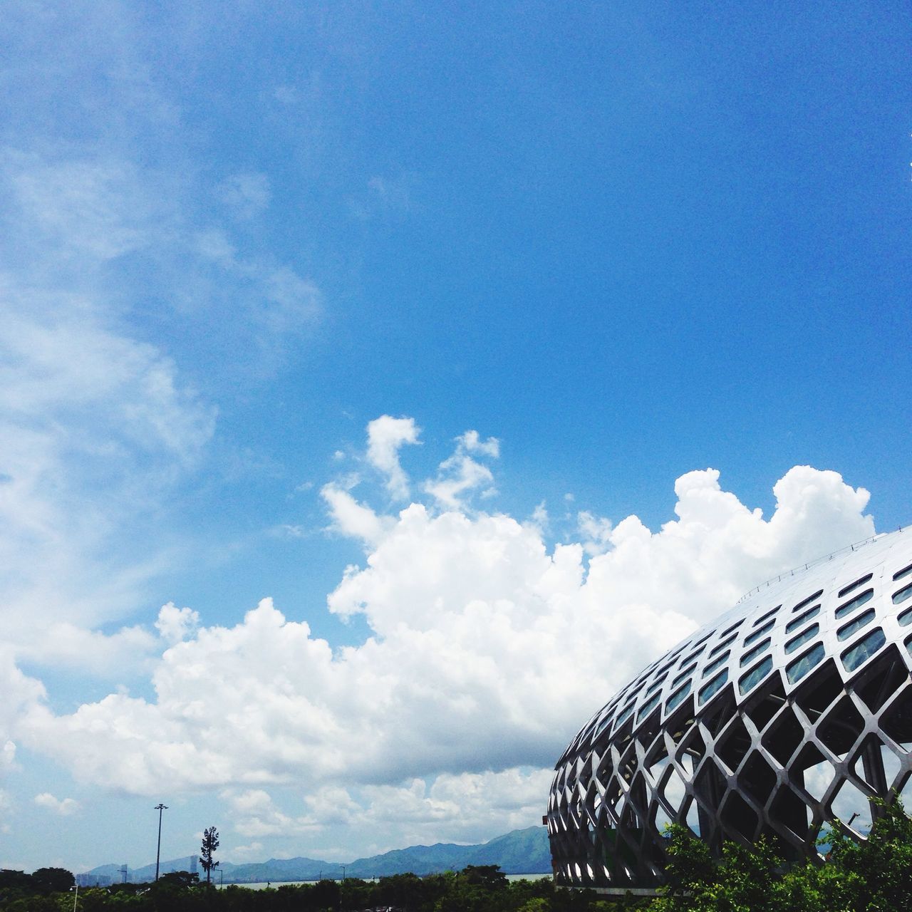 sky, low angle view, cloud - sky, blue, built structure, cloud, architecture, metal, day, cloudy, building exterior, outdoors, railing, no people, transportation, metallic, nature, part of, sunlight, mode of transport