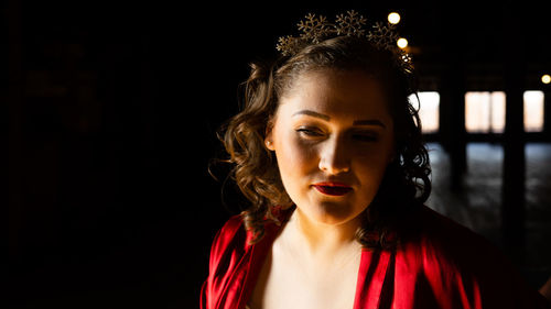 Close-up of young woman against black background