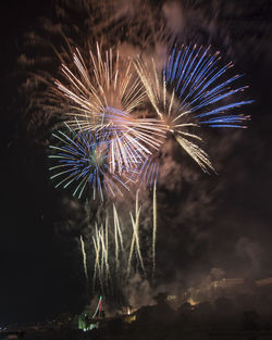 Low angle view of firework display at night