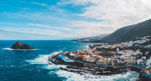 Panoramic view of sea and buildings against sky