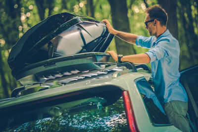 Side view of man opening roofrack