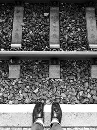 Low section of man standing on railroad track