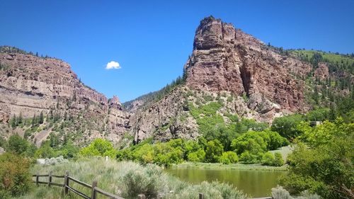 Scenic view of river and mountains against sky