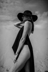 Woman wearing hat sitting on beach